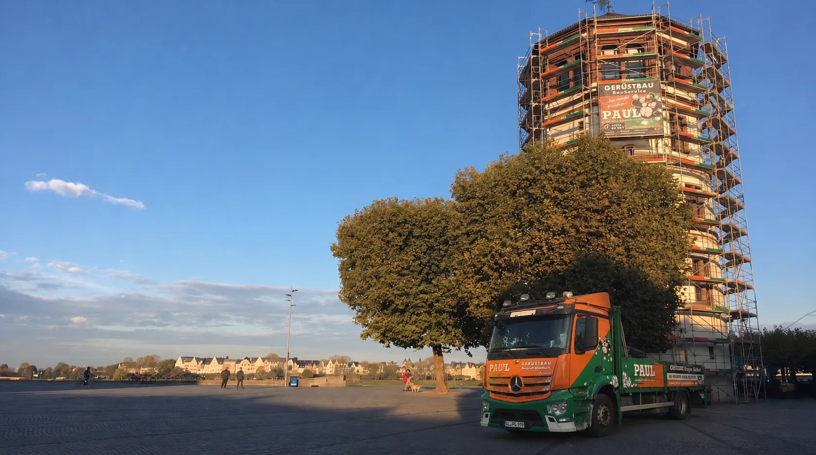 Gerüstbau in Düsseldorf: vollflächig eingerüsteter Rundturm am Rheinufer mit Paul-Banner, davor der Paul-Gerüstbau-LKW
