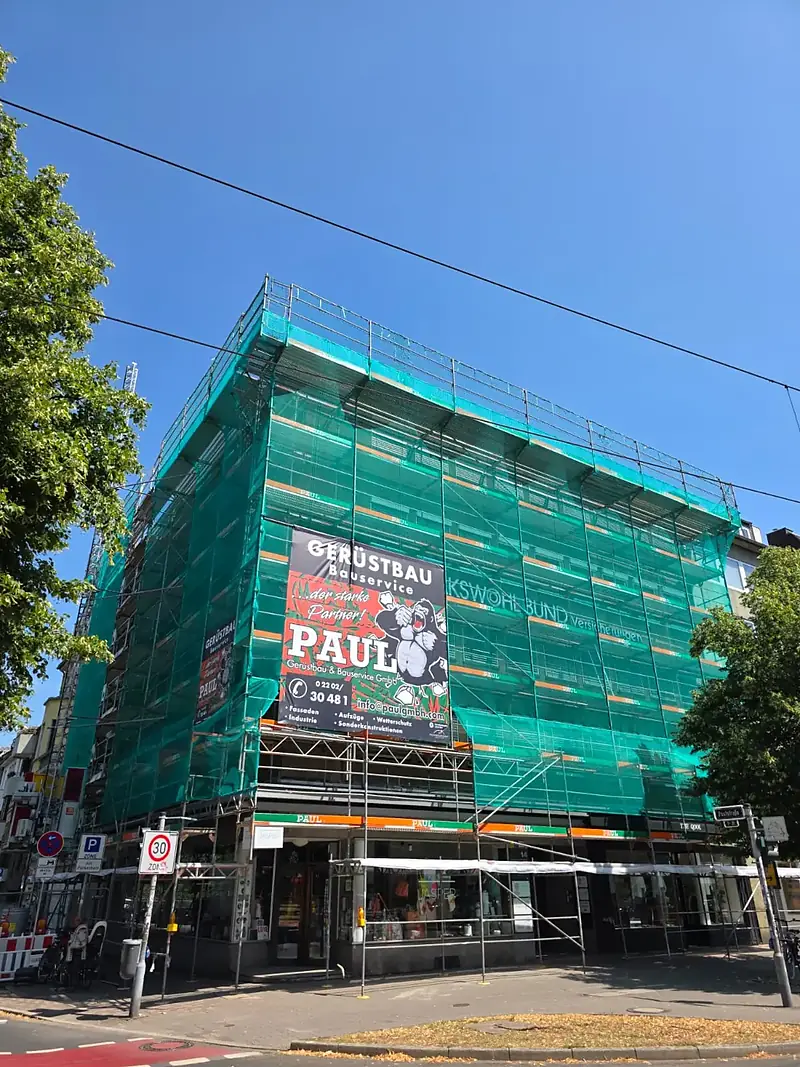 Fassadengerüst mit Schutznetz an einem Eckhaus in der Düsseldorfer Carlstadt – Paul Gerüstbau