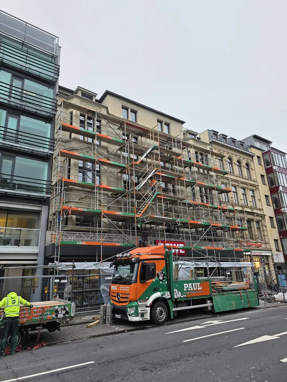 Fassadengerüst an einem Geschäftshaus in der Kölner Innenstadt, davor der Lkw von Paul Gerüstbau